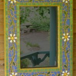 Daisys with a blue and green background on a mosaic mirror