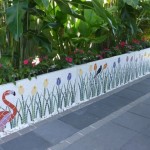 Flamingoes and colourful tulips theme on a white mosaic background on planters