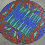mosaic backgammon table surrounded by leaves and brown background