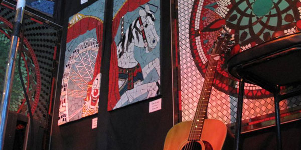 closeup of a mosaic exhibition with guitar in the foreground