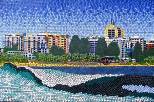 Mosaic Beach scene from Mooloolaba with a wave and buildings in background
