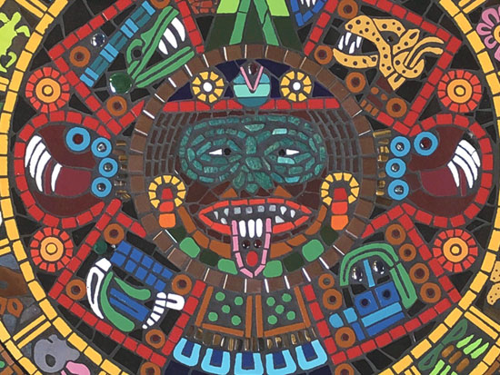 Closeup of face on the Aztec sunstone mosaic artwork featuring green adventurine